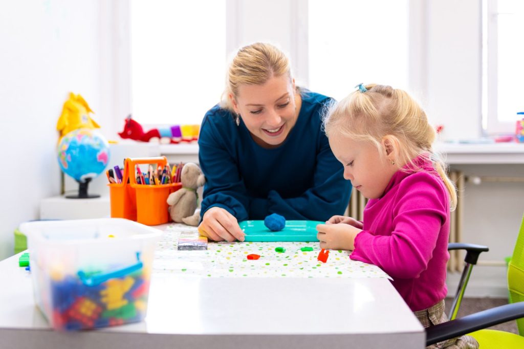 Support worker along with autistic child doing art session